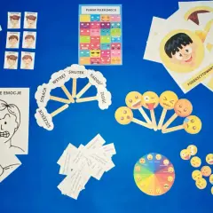 Materiały do zajęć o emocjach: karty z buźkami, plakat, koło emocji i pomoce do opisywania uczuć.