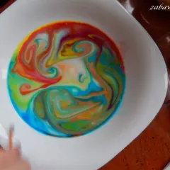 Kolorowe wzory wirują w mleku, tworząc magiczne malowanie na mleku.