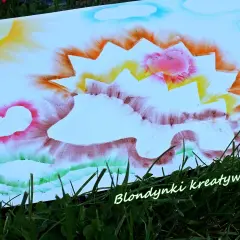 Kolorowy jeż do druku, namalowany wesołymi barwami. Słońce, chmurki i zielona trawa tworzą radosną scenerię.