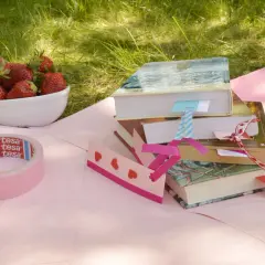 Urocze diy zakładki do książki z serduszkami, taśma maskująca i miseczka truskawek na trawie.