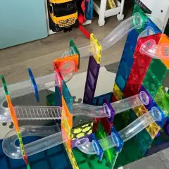 Kolorowe budowle z klocków plastikowych tworzą tor dla kulek. Dziecko bawi się, budując skomplikowane konstrukcje.