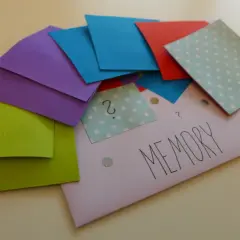 Kolorowe kartki do gry memory do druku, ułożone na kopercie z napisem "MEMORY".