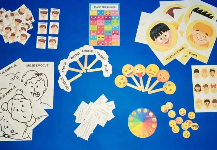 Materiały do zajęć o emocjach: karty z buźkami, plakat, koło emocji i pomoce do opisywania uczuć.