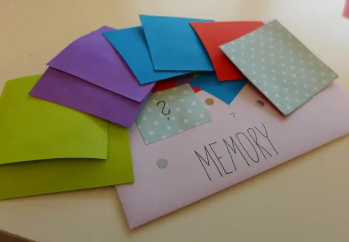 Kolorowe kartki do gry memory do druku, ułożone na kopercie z napisem "MEMORY".