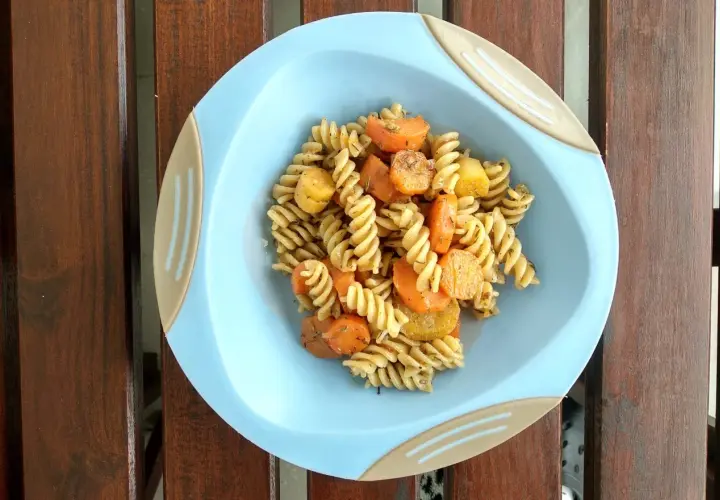 Kolorowy obiad dla dzieci: makaron fusilli z kawałkami marchewki i ziemniaków, doprawiony ziołami.