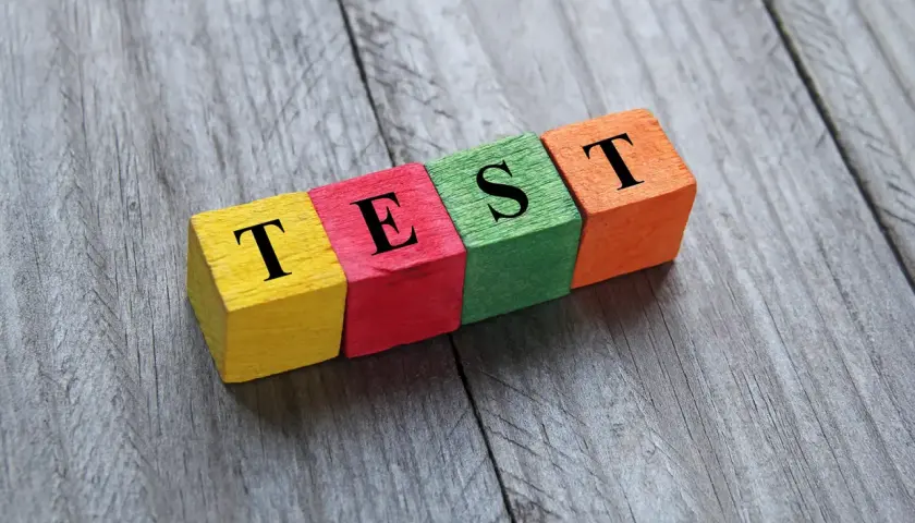 Kolorowe klocki z literami tworzą napis "TEST". Może to być test na neofobię żywieniową, sprawdzający gotowość do próbowania nowych smaków.