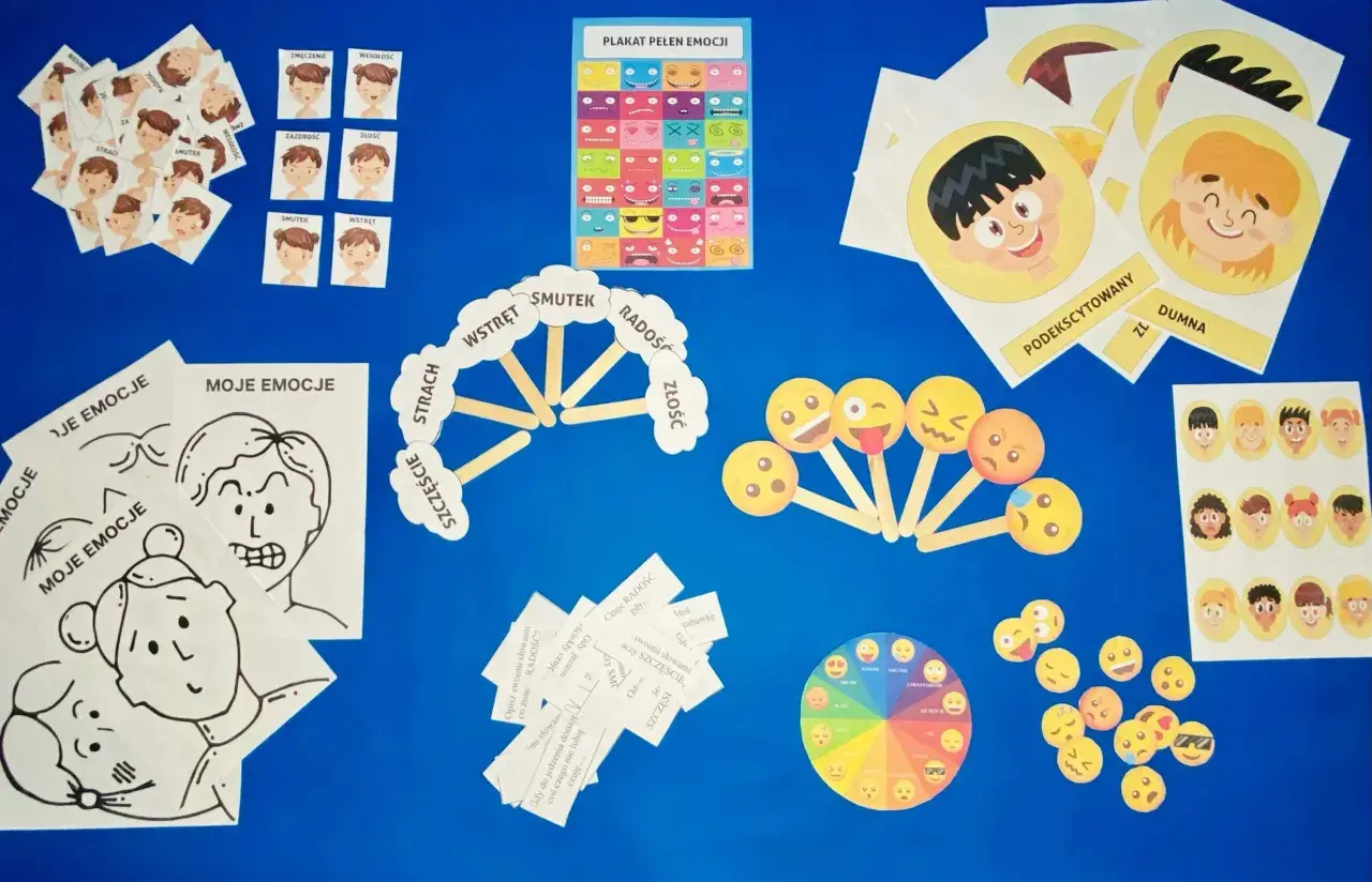 Materiały do zajęć o emocjach: karty z buźkami, plakat, koło emocji i pomoce do opisywania uczuć.