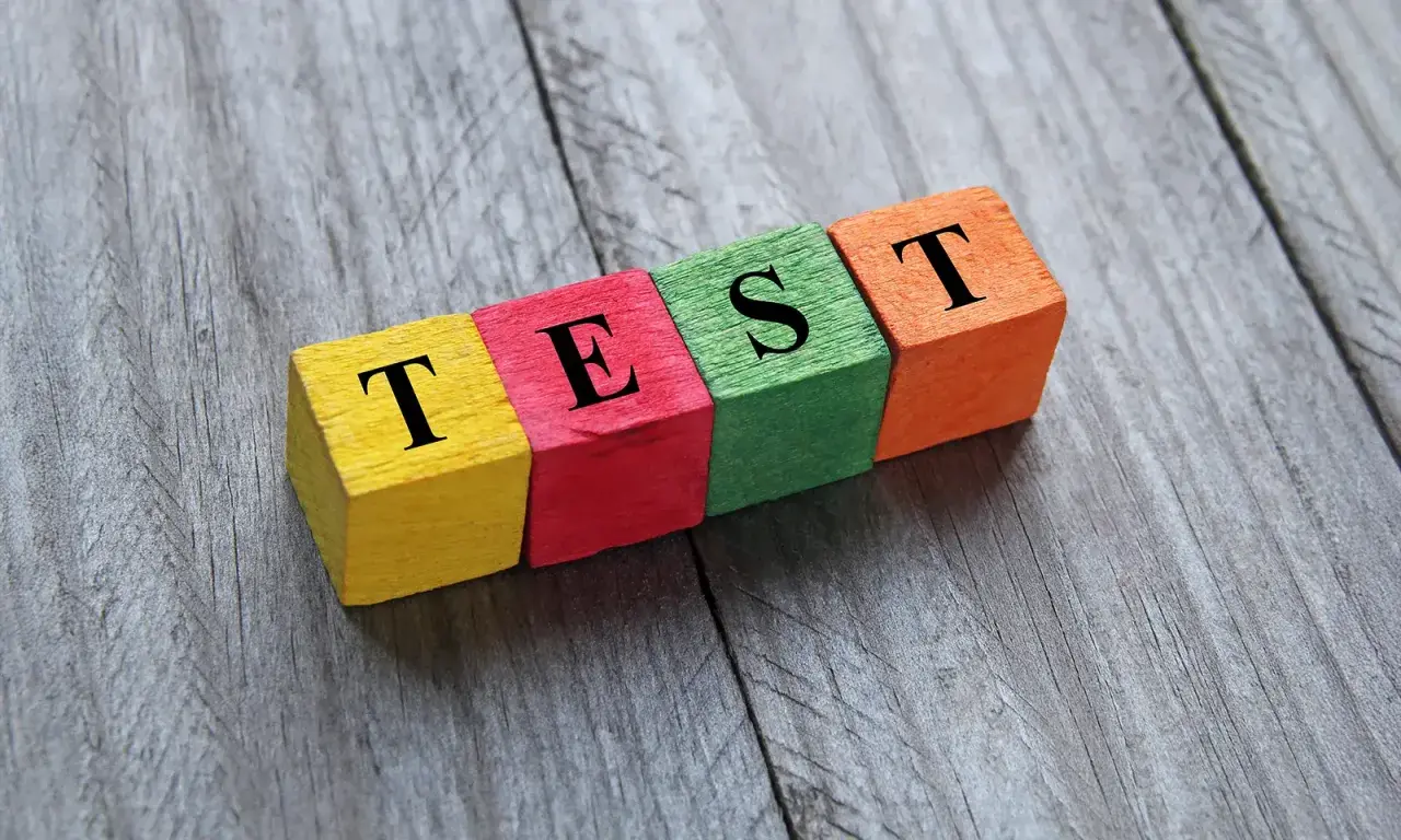 Kolorowe klocki z literami tworzą napis "TEST". Może to być test na neofobię żywieniową, sprawdzający gotowość do próbowania nowych smaków.