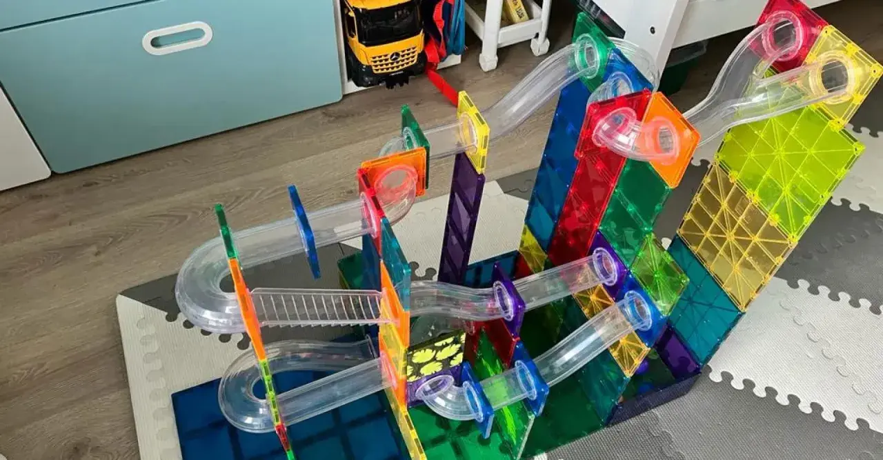 Kolorowe budowle z klocków plastikowych tworzą tor dla kulek. Dziecko bawi się, budując skomplikowane konstrukcje.