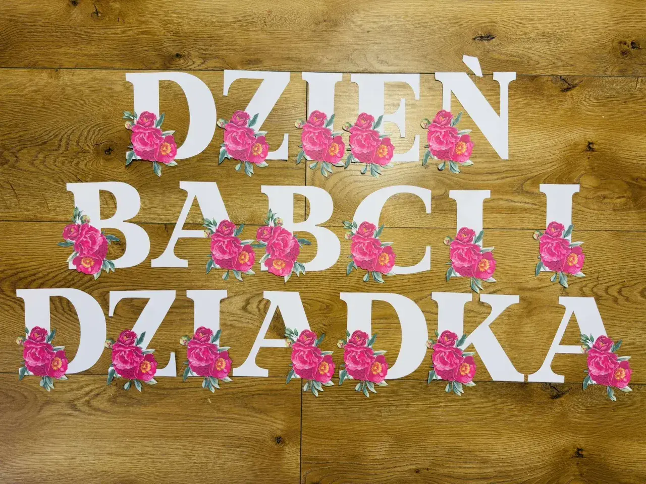 Napis "Dzień Babci i Dziadka" do druku, ozdobiony różowymi piwoniami. Idealny na uroczystość!