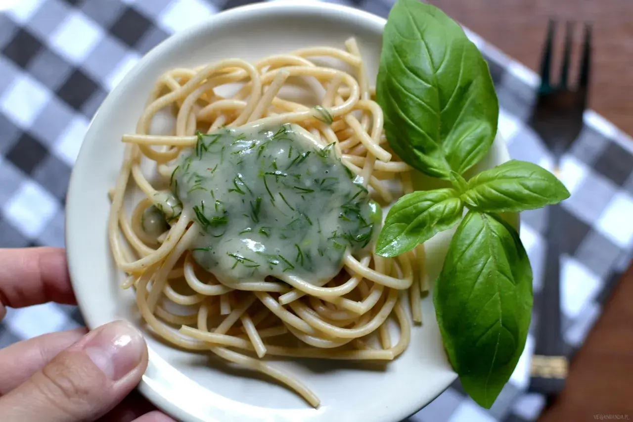 Delikatny makaron spaghetti z kremowym, zielonym sosem koperkowym, idealny jako sos koperkowy dla niemowlaka. Udekorowany świeżymi listkami bazylii.