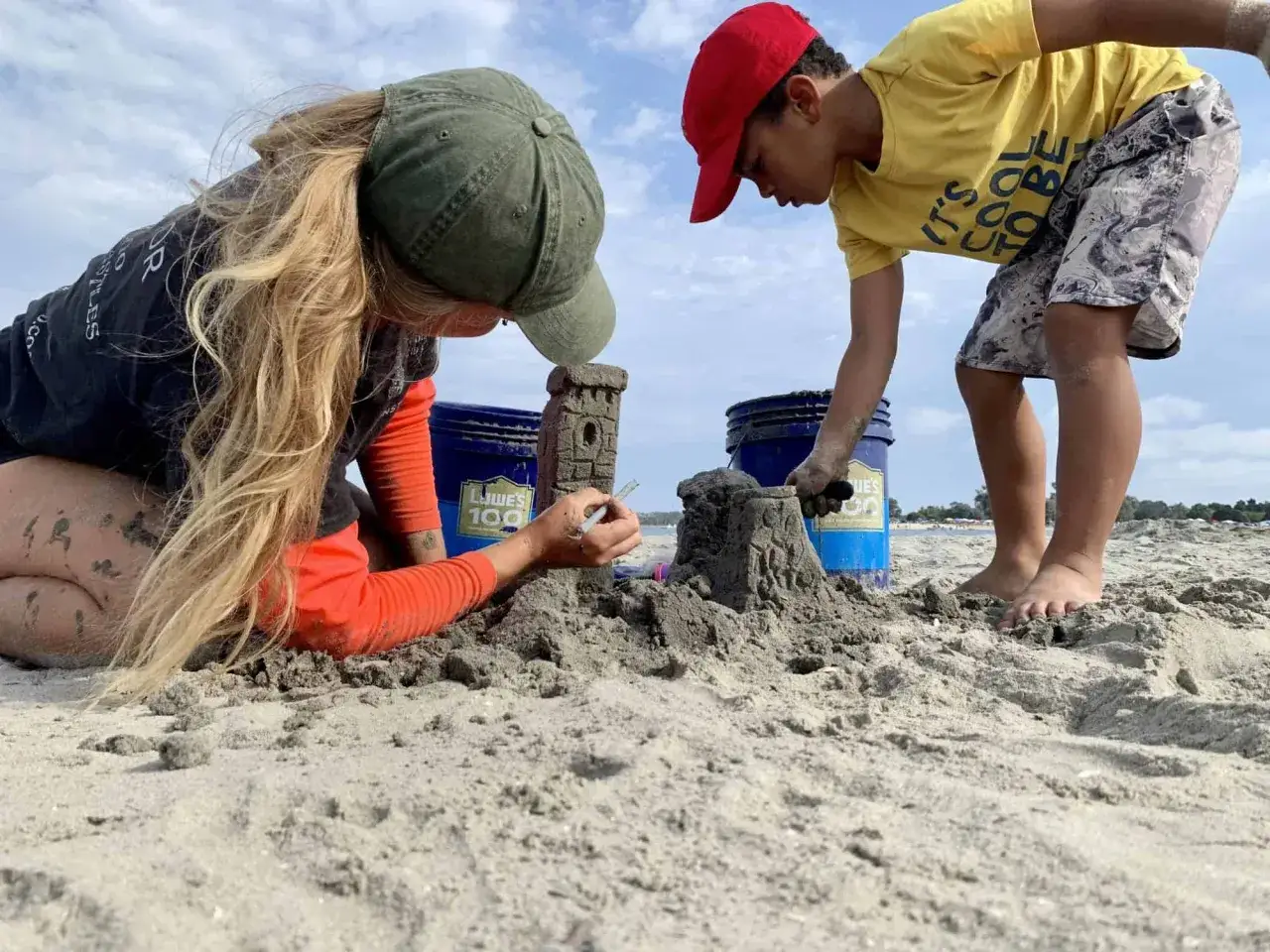 Dzieci budują zamki z piasku na plaży. Tworzą wspaniałe budowle z piasku dla dzieci, bawiąc się w słońcu.