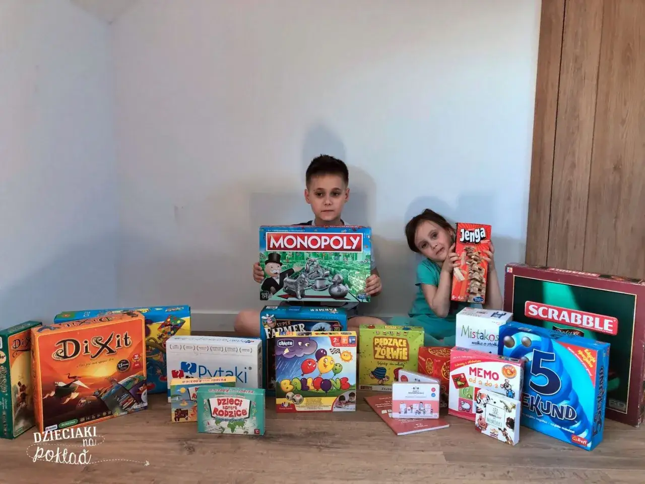 Dzieci z dumą prezentują swoje gry planszowe, w tym Monopoly i Jengę. To idealny zestaw na rodzinne popołudnie, gdzie gra 7+ zapewni mn&oacute;stwo śmiechu.