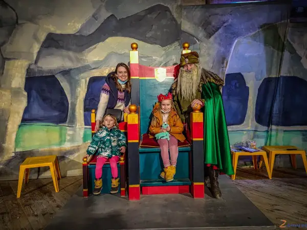 Rodzina w kopalni soli w Wieliczce spotyka króla. Dzieci siedzą na tronach, a mama i król stoją obok.